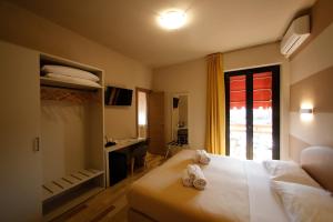 a bedroom with a bed and a desk and a window at Hotel Primavera in Peschiera del Garda