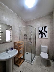 a bathroom with a shower and a toilet and a sink at Bay Water 21 in St. Julianʼs +9 photos