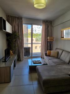 a living room with a couch and a large window at Bay Water 21 in St. Julianʼs