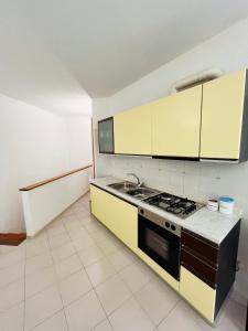 a kitchen with yellow cabinets and a stove at Ischia Casareccia in Serrara Fontana