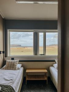 a bedroom with two beds and a large window at Guesthouse Reynir in Reynir