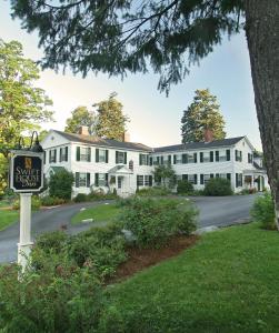 a large white house with a sign in front of it at Swift House Inn in Middlebury