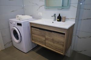 a bathroom with a sink and a washing machine at Tritea Apartments in Golem