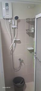 Un baño con ducha y un inodoro. en Sandstone Unit Brenthill Condo, en Baguio