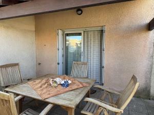 einen Holztisch und Stühle auf einer Veranda in der Unterkunft HOLIDAYLAND VILLA 217 T2 6 couchages NARBONNE PLAGE in Narbonne-Plage