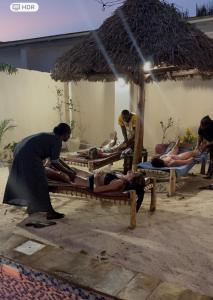 a group of people laying on beds on the beach at Peace And Color Limited Guest House in Nungwi