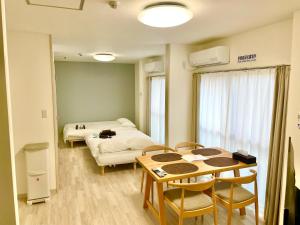 una stanza con un letto, un tavolo e delle sedie di Villa Hayabusa ad Osaka