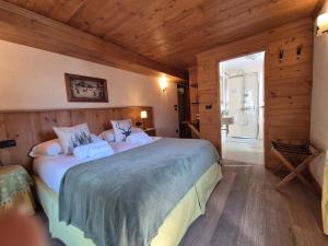 a bedroom with a large bed in a room with wooden walls at Hotel Dente Del Gigante in Courmayeur
