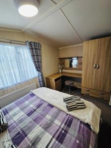 a bedroom with a bed and a desk at The Canny View at Three Lochs Holiday Park in Balminnoch 3 bedroom sleeps upto 8 guests in Newton Stewart +16 photos