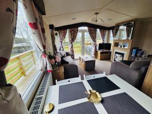 a living room with a table in a van at The Canny View at Three Lochs Holiday Park in Balminnoch 3 bedroom sleeps upto 8 guests in Newton Stewart
