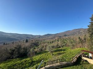 a bridge on a hill with a mountain in the background at Appartamento Zafferano in LʼOpaco
