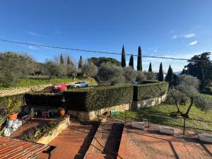 a stone wall with hedges next to a parking lot at Appartamento Zafferano in LʼOpaco