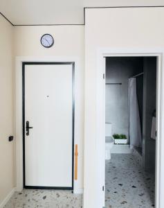 a door leading into a bathroom with a clock on the wall at Студия красивая in Almaty +49 photos