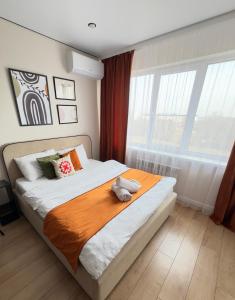 a bedroom with a bed with a stuffed animal on it at Студия красивая in Almaty