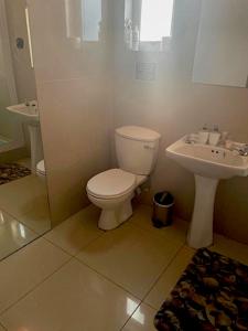 a bathroom with a toilet and a sink at 90 On Wellington Cottage in Port Elizabeth