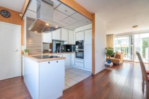 an open kitchen with white cabinets and a large window at Casa 82 in Arnhem
