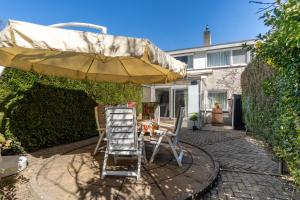 a patio with a ladder and an umbrella and chairs at Casa 82 in Arnhem