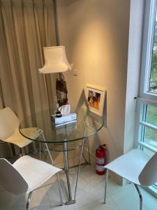 a glass table with two chairs and a lamp at Cristians lägenhet in Kata Beach
