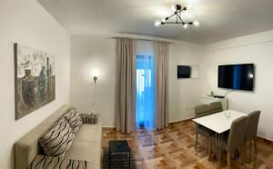 a living room with a table and a dining room at Apartments Derado in Supetar