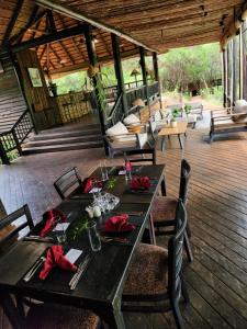 a table and chairs on a wooden deck at Ubizane Zululand Tree Lodge in Hluhluwe
