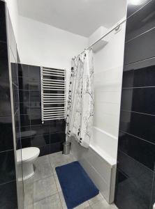 baño con aseo y alfombra azul en Apartament Królewiecka 54b/26, en Mrągowo