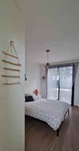 ein weißes Schlafzimmer mit einem Bett und einem Fenster in der Unterkunft Kaze Océane in Brétignolles-sur-Mer + 5 Fotos