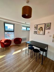マンチェスターにあるCity Centre 2 bed apartment with a balconyのテーブルと椅子とソファのあるリビングルーム