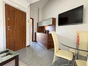 a living room with a glass table and a television at Apartamenty Bryza - Family Home - Parking - Komandorska 3E-3G in Świnoujście