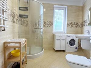 a bathroom with a shower and a washing machine at Apartamenty Bryza - Family Home - Parking - Komandorska 3E-3G in Świnoujście +54 photos