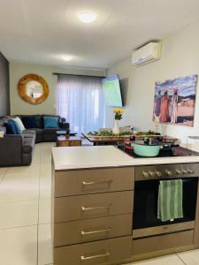 a kitchen with a stove and a living room at NJ MERENSKY 1 Windhoek in Windhoek