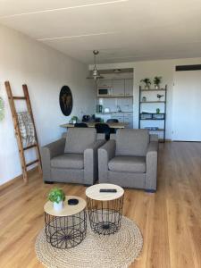 a living room with two couches and a table at IJsselmeerzicht sfeervol appartement aan het strand! Privé parkeerplaats in Makkum