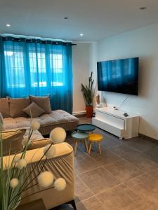 ein Wohnzimmer mit Couch und Flachbildfernseher in der Unterkunft Maison proche Nancy Golf, Forêt & Calme à Pulnoy in Pulnoy