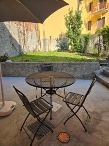 a table and two chairs with an umbrella at La Torretta in Lanzo dʼIntelvi