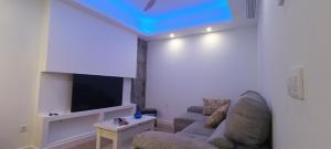 a living room with a couch and a flat screen tv at Apartamento Luxe Triana in Seville