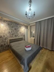 a bedroom with a large bed and a chandelier at monolit residens 6C blok in Tbilisi City