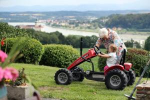 an older woman playing with a child in a toy car at Naglhof in Gottsdorf