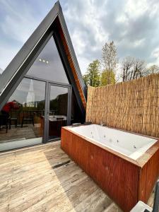 une grande baignoire sur une terrasse avec une grande fenêtre dans l'établissement Sapanca life garden bungalov, à Sapanca