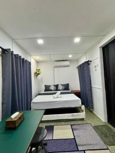 a small room with a bed and a table at Pok Mat Beach Cabin in Marang