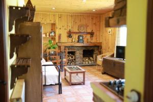a living room with a fireplace and a table at El arroyo del valle in Navaconcejo