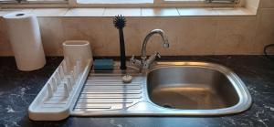 a kitchen sink with a dish drying rack next to it at Salt & Cellar - Paarl - Self Catering Apartment in Paarl +45 photos