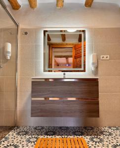 a bathroom with a mirror and a wooden bench at Cortijo Al-Andalus in Órgiva