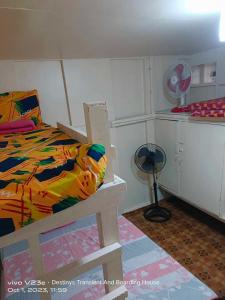 Un dormitorio con una cama y un ventilador. en Destiny's Transient and Boarding House 2nd, en Baguio