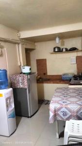 Una cocina con un refrigerador y una mesa dentro. en Destiny's Transient and Boarding House 2nd, en Baguio