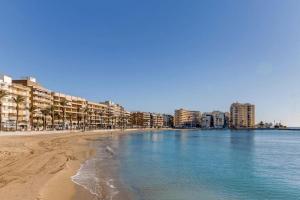 Una vista de una playa con edificios y el océano. en Calle Galeon, en Torrevieja