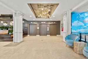 a large room with a lobby with blue chairs at KOT suites Inner Harbor in Baltimore
