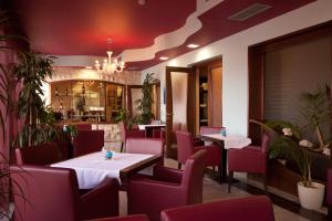 a restaurant with tables and chairs and a menu at Hotel Zlatna Vala in Umag