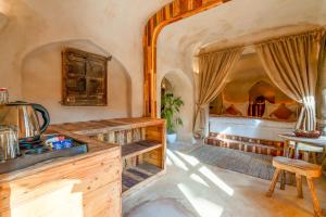 Sunanda by 1810AD - A Boutique Organic Retreat في بوشكار: مطبخ مع مغسلة وسرير في غرفة