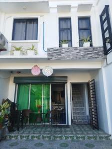 a house with a patio with chairs and a table at De Richness in Tagbilaran City