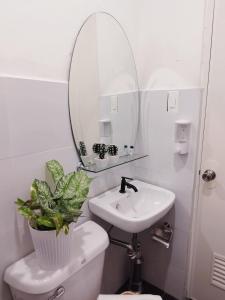 a bathroom with a sink and a mirror over a toilet at De Richness in Tagbilaran City +5 photos