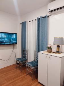 a living room with two chairs and a tv at De Richness in Tagbilaran City